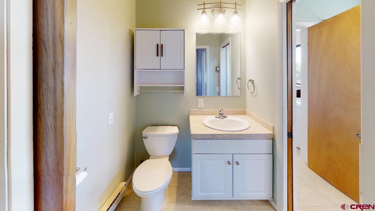 16407 Happy Hollow Road Cedaredge, CO 81413 - Photo 14 of 35 a bathroom with a toilet a sink and mirror