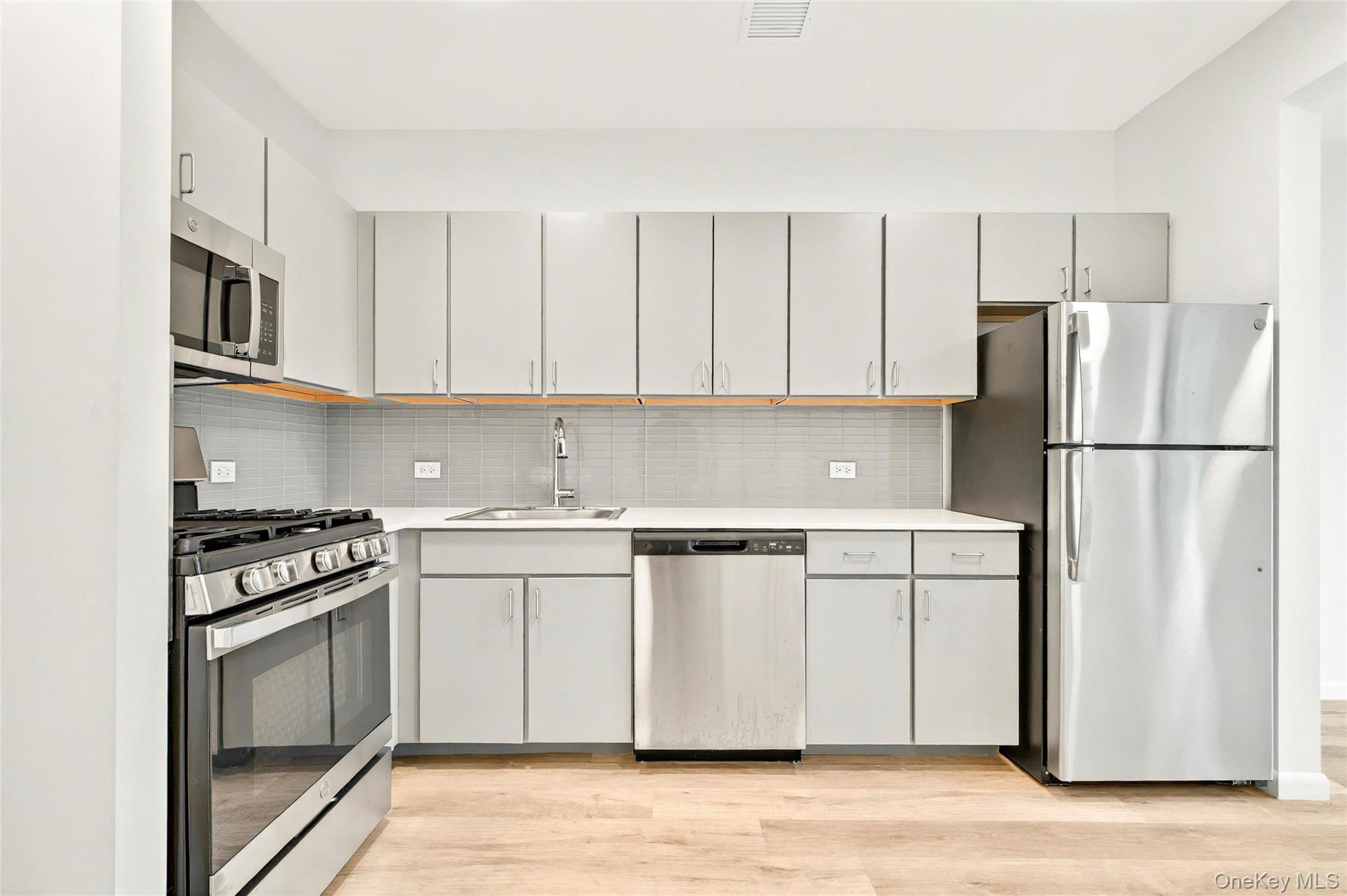1739 Lacombe Avenue, Unit 1B Bronx, NY 10473 - Photo 12 of 23 a kitchen with stainless steel appliances granite countertop a refrigerator stove a sink and dishwasher