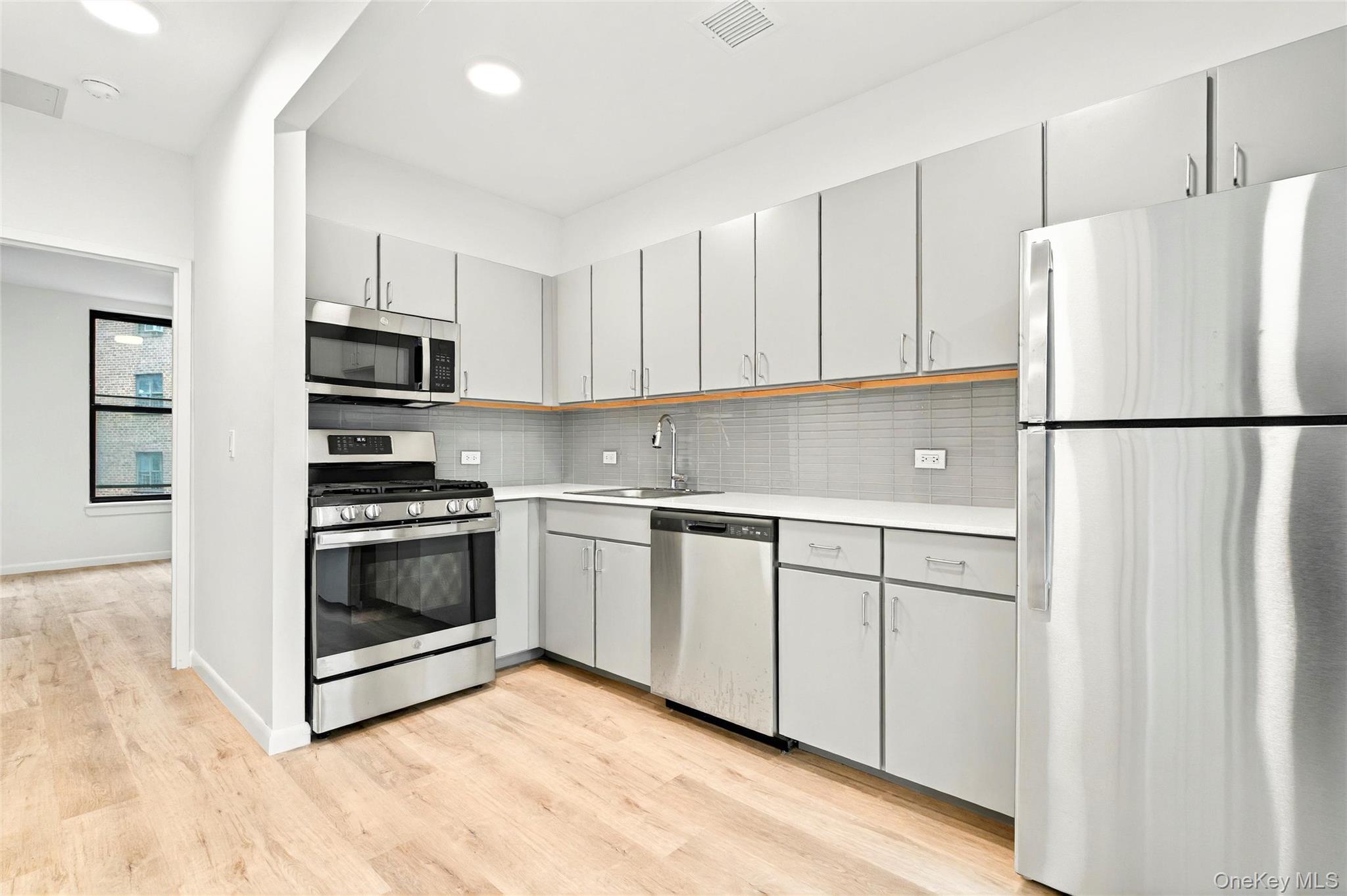 1739 Lacombe Avenue, Unit 1B Bronx, NY 10473 - Photo 10 of 23 a kitchen with white cabinets and white appliances