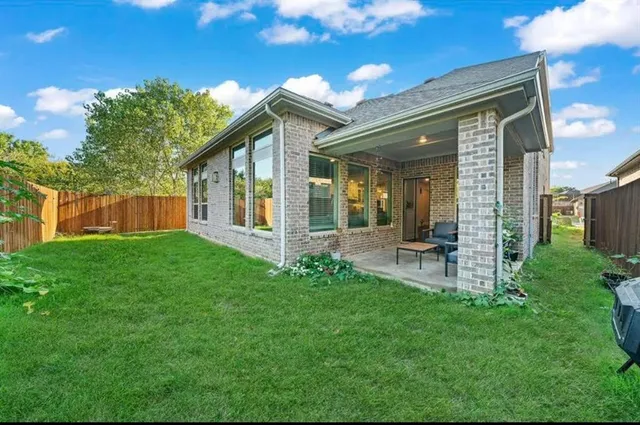 a view of a chair and table in backyard of the house