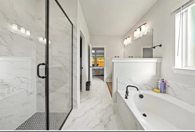 a bathroom with a tub sink and mirror