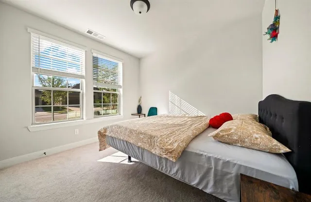 a bedroom with a bed and a large window