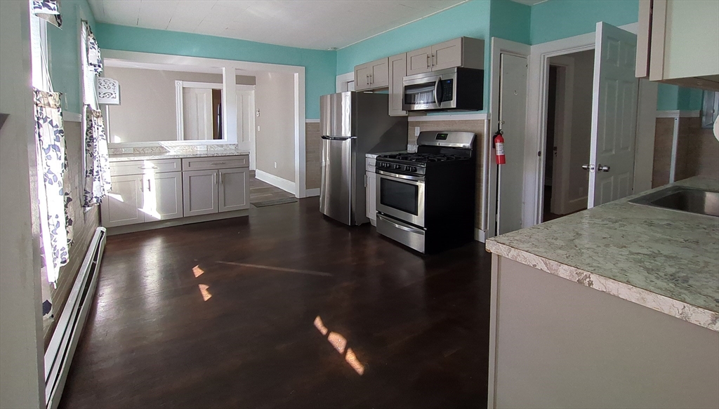 7 Cherry Street Lynn, MA 01902 - Photo 18 of 42 a kitchen with stainless steel appliances granite countertop a refrigerator a stove and a sink