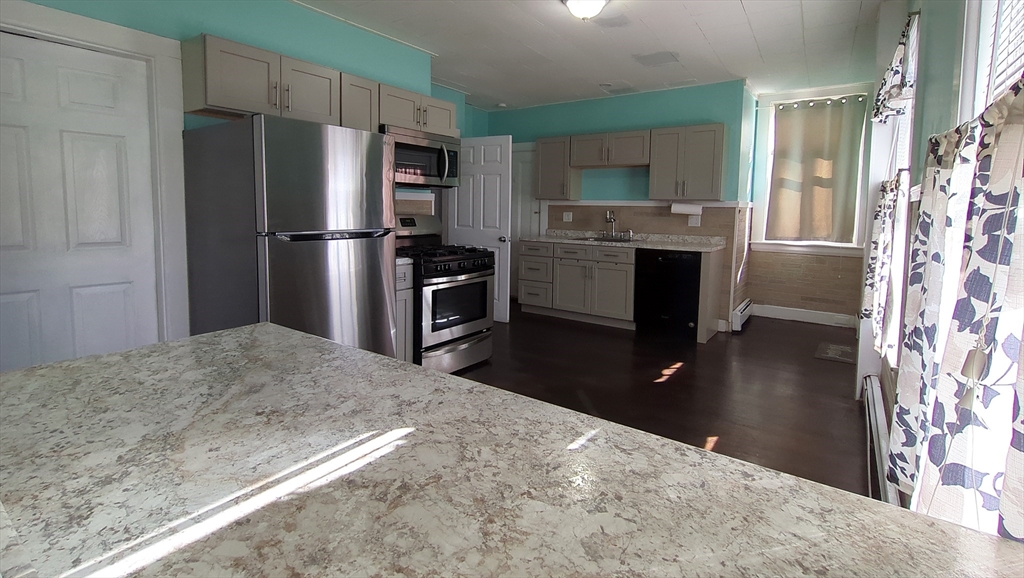 7 Cherry Street Lynn, MA 01902 - Photo 19 of 42 a kitchen with granite countertop a refrigerator stove and oven