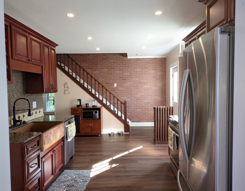 7 Cherry Street Lynn, MA 01902 - Photo 5 of 42 a kitchen with stainless steel appliances granite countertop a refrigerator a stove and a sink with wooden floors