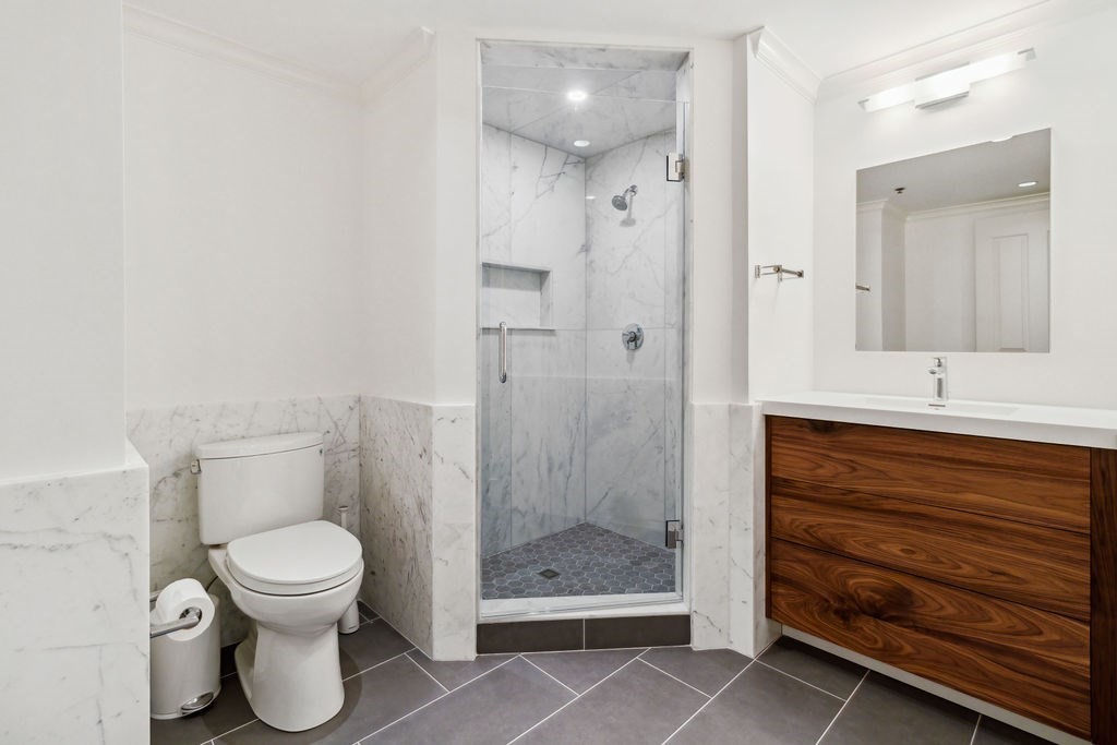 157 Newbury Street, Unit 4 Boston, MA 02116 - Photo 14 of 26 a bathroom with a toilet a sink and glass door