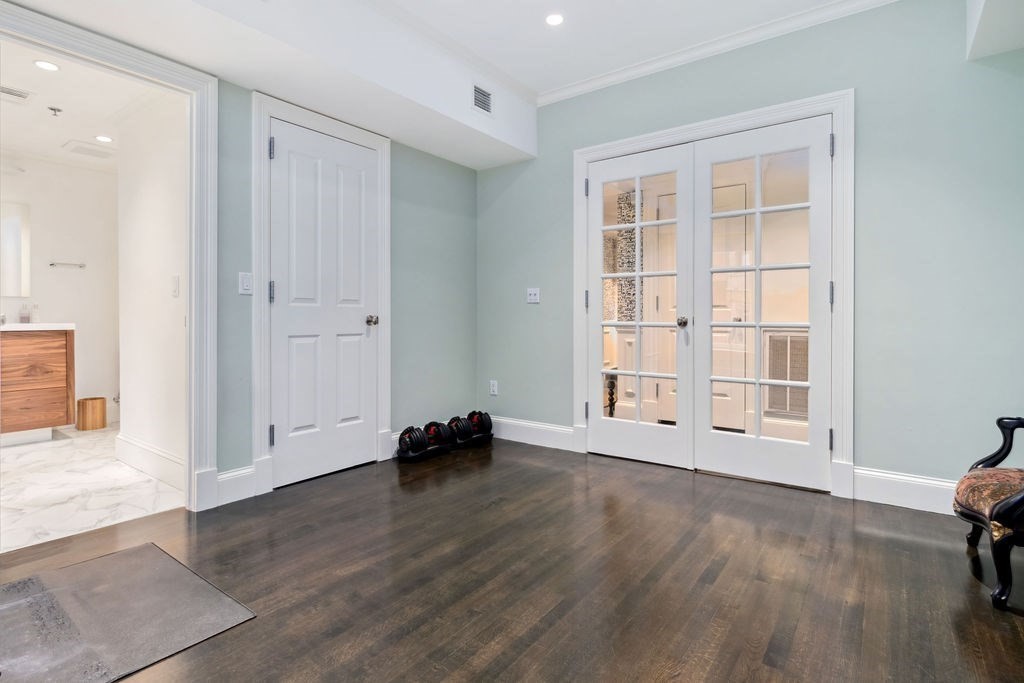 157 Newbury Street, Unit 4 Boston, MA 02116 - Photo 21 of 26 an empty room with wooden floor and windows