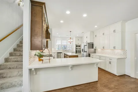 a large kitchen with stainless steel appliances lots of counter top space and cabinets