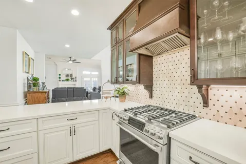 a kitchen with stainless steel appliances granite countertop a sink a stove cabinets and living room view