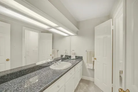 a bedroom with a large bed chandelier and a window