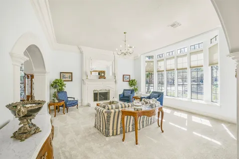 a living room with furniture a fireplace and a chandelier