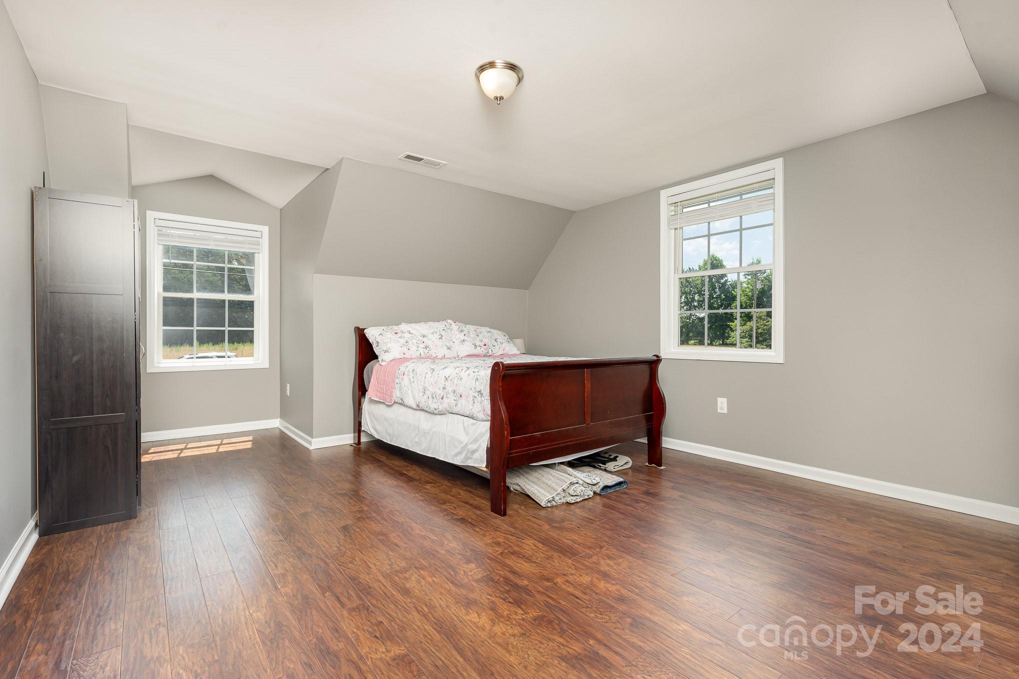 256 Hemlock Road Cleveland, NC 27013 - Photo 23 of 32 a bedroom with a bed and wooden floor