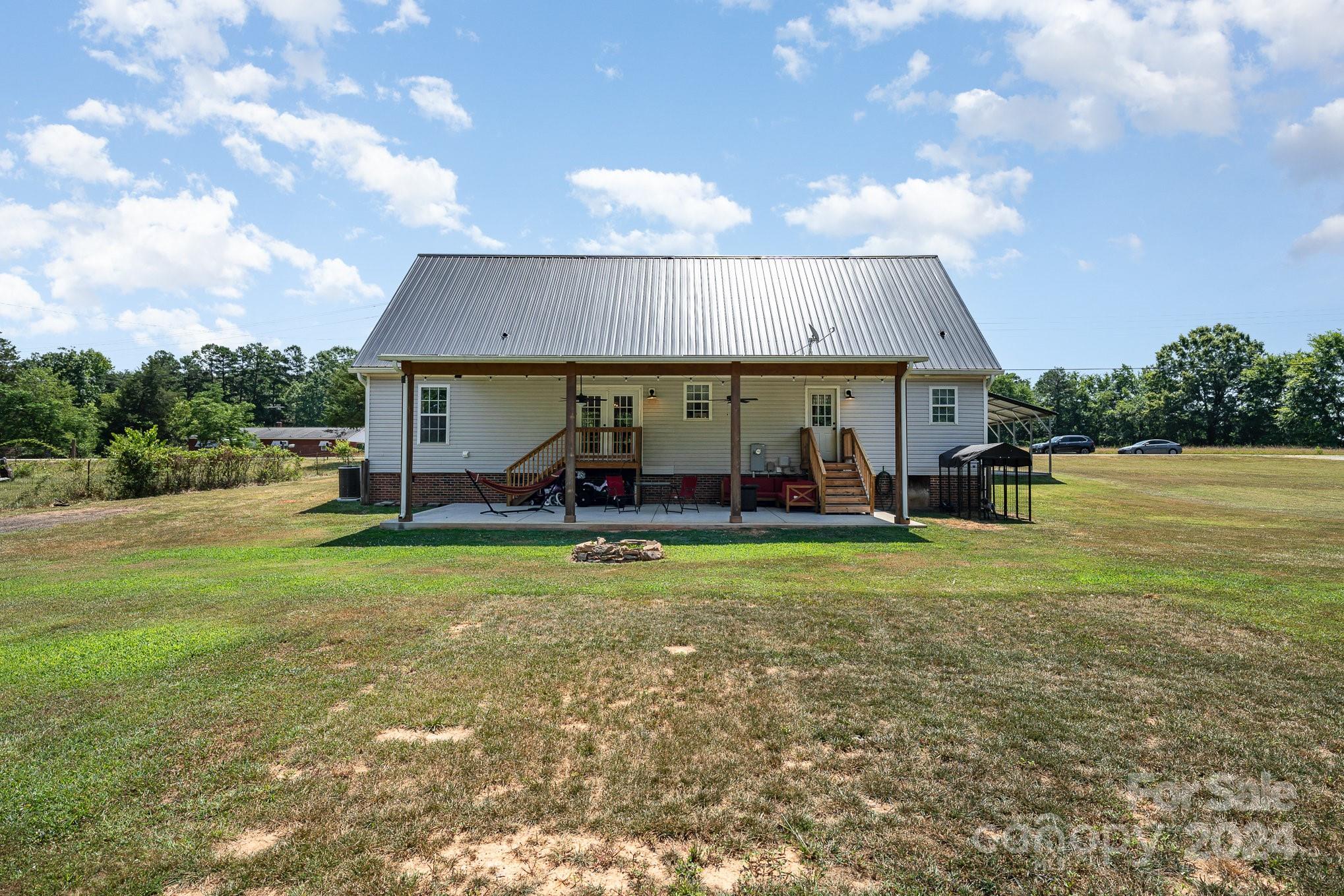 256 Hemlock Road Cleveland, NC 27013 - Photo 27 of 32 a view of a house next to a big yard with plants and large trees