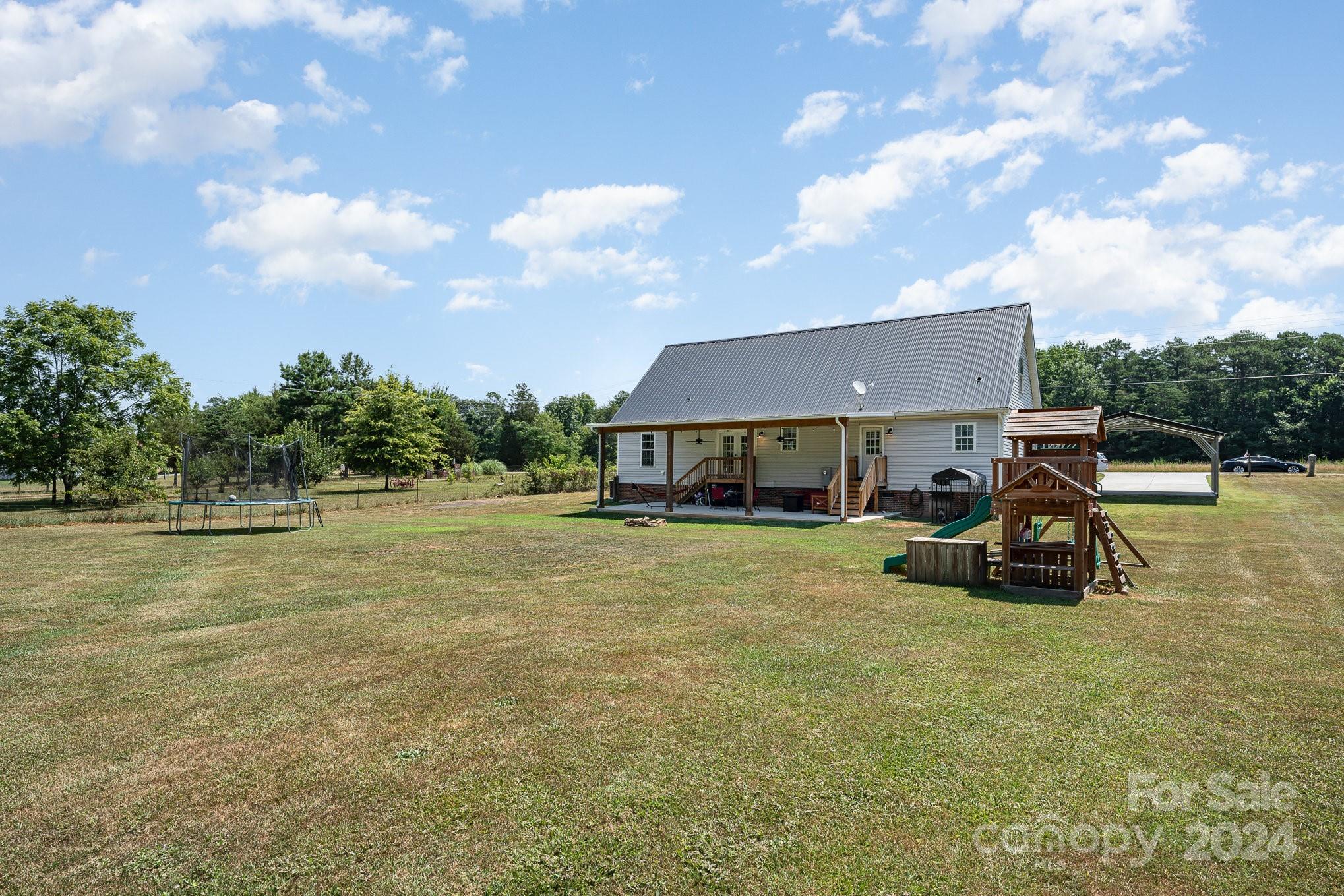 256 Hemlock Road Cleveland, NC 27013 - Photo 28 of 32 a view of a house with backyard patio and garden