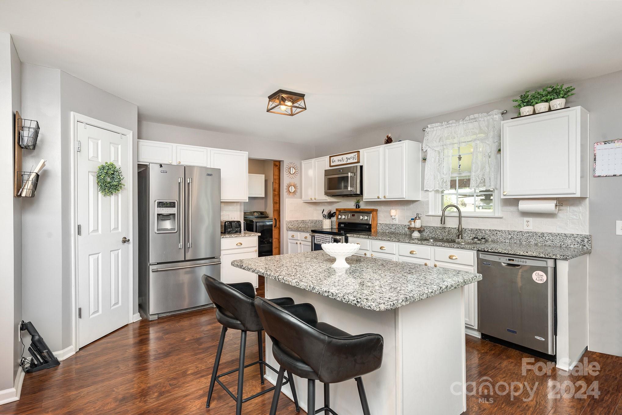 256 Hemlock Road Cleveland, NC 27013 - Photo 6 of 32 a kitchen with granite countertop kitchen island cabinets and refrigerator