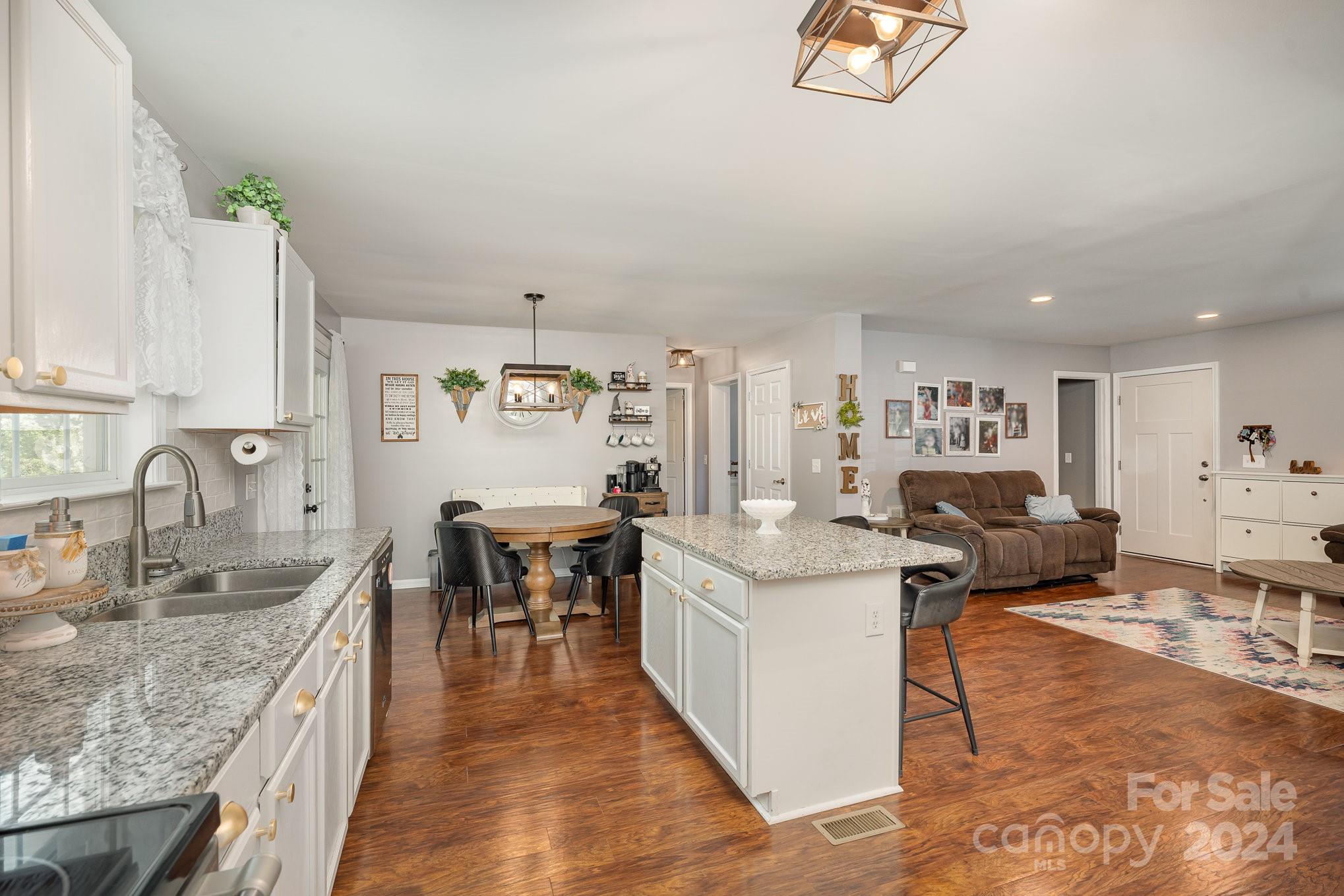 256 Hemlock Road Cleveland, NC 27013 - Photo 7 of 32 a large kitchen with kitchen island a sink table and chairs