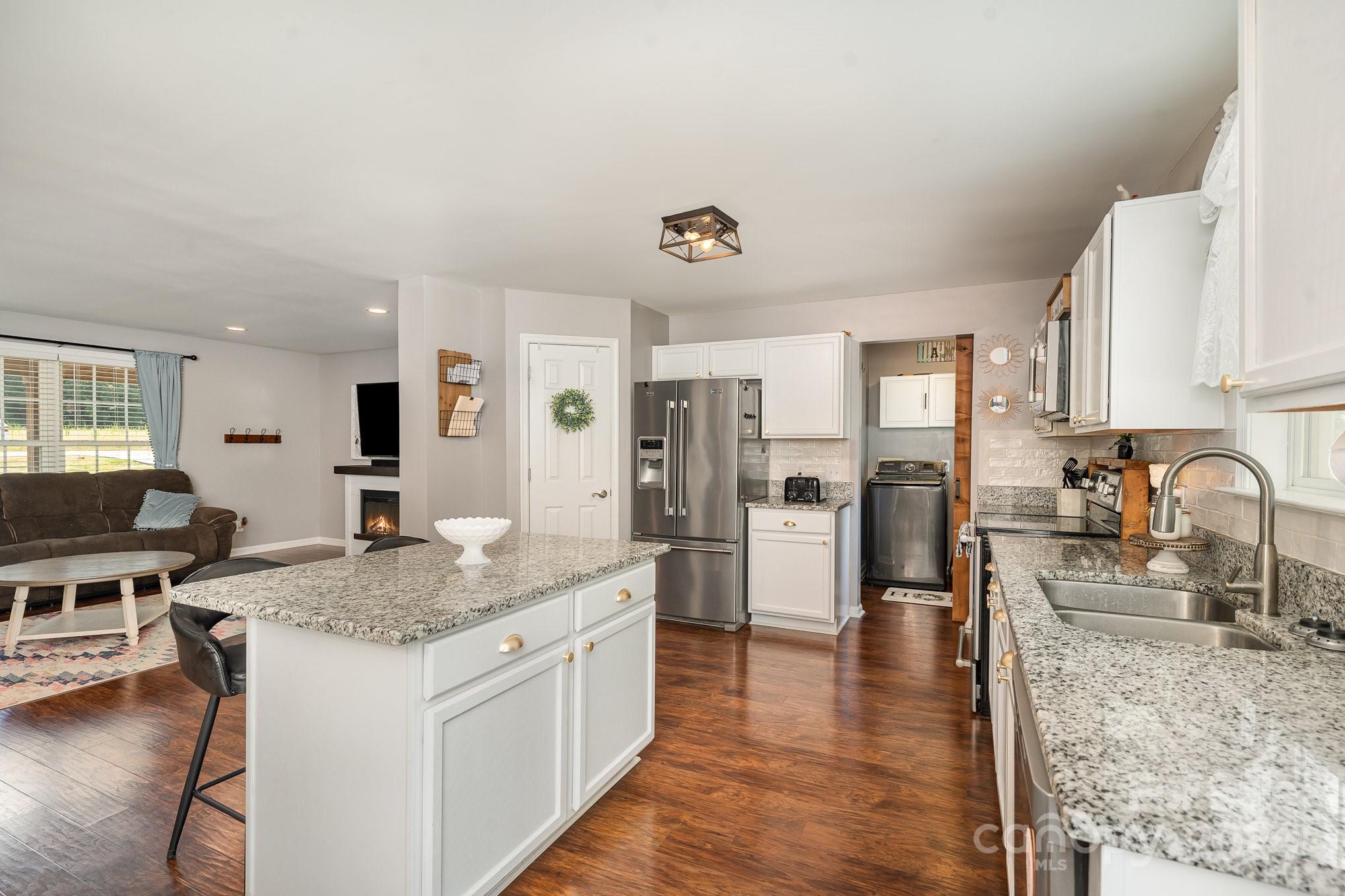 256 Hemlock Road Cleveland, NC 27013 - Photo 8 of 32 a kitchen with stainless steel appliances granite countertop a stove and a sink