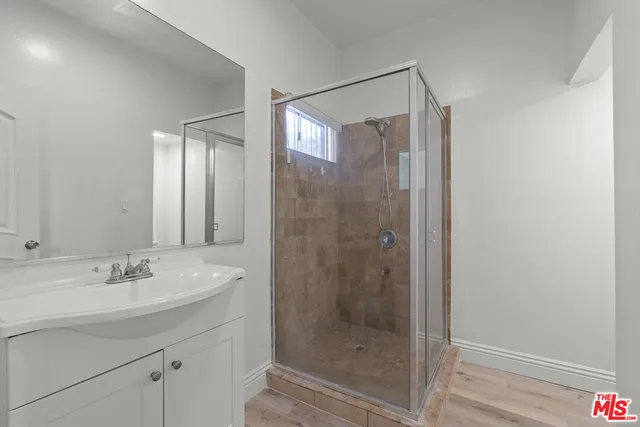 a bathroom with a shower sink and mirror