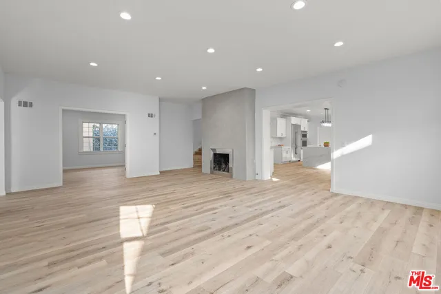 a view of empty room with wooden floor and window