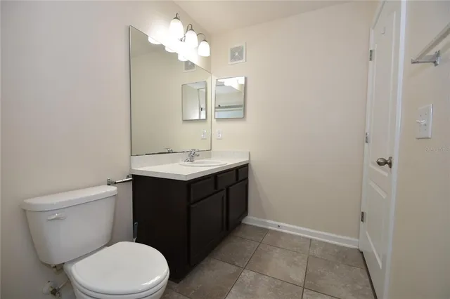 a bathroom with a sink vanity and a toilet