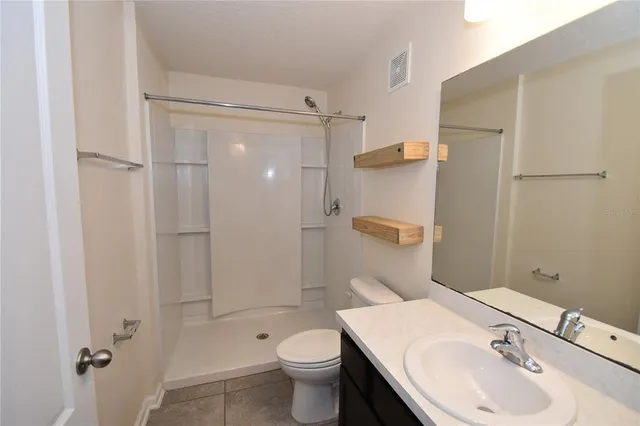 a bathroom with a toilet sink vanity and mirror