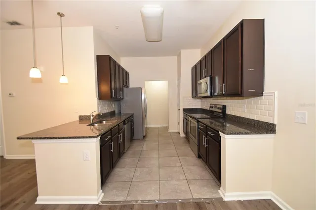 a kitchen with a stove sink and cabinets