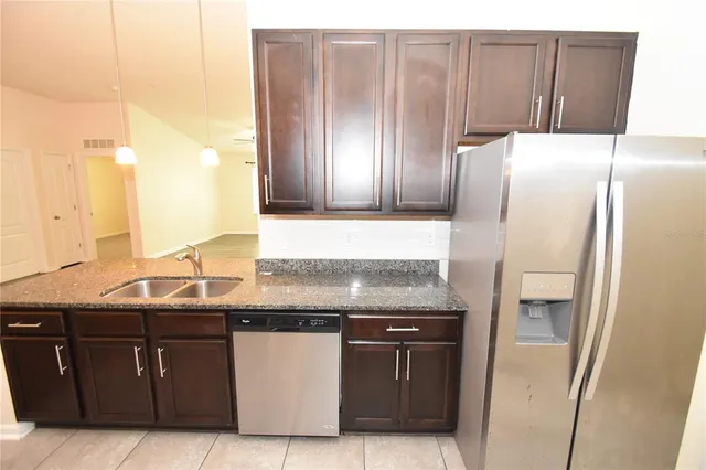 a kitchen with stainless steel appliances granite countertop a refrigerator and a sink