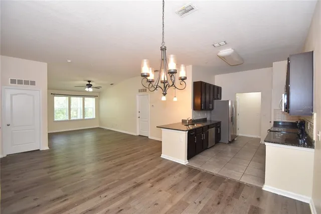 a kitchen with granite countertop a stove and a wooden floors