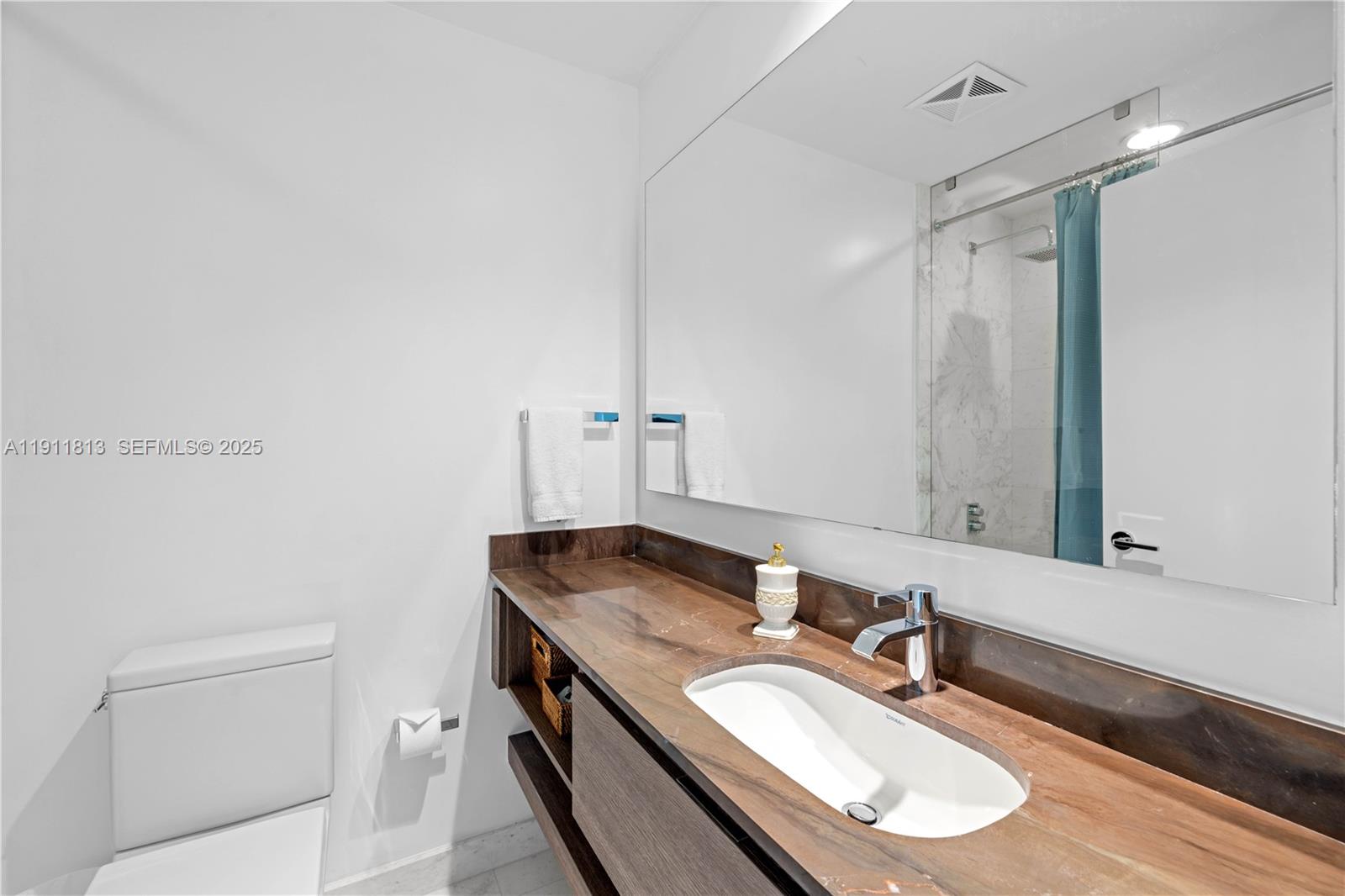 350 Ocean Drive, Unit 301N Key Biscayne, FL 33149 - Photo 12 of 41 a bathroom with a granite countertop sink a toilet and a mirror