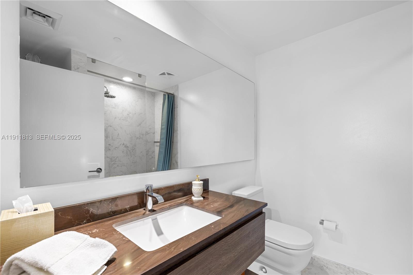 350 Ocean Drive, Unit 301N Key Biscayne, FL 33149 - Photo 14 of 41 a bathroom with a sink toilet vanity and mirror