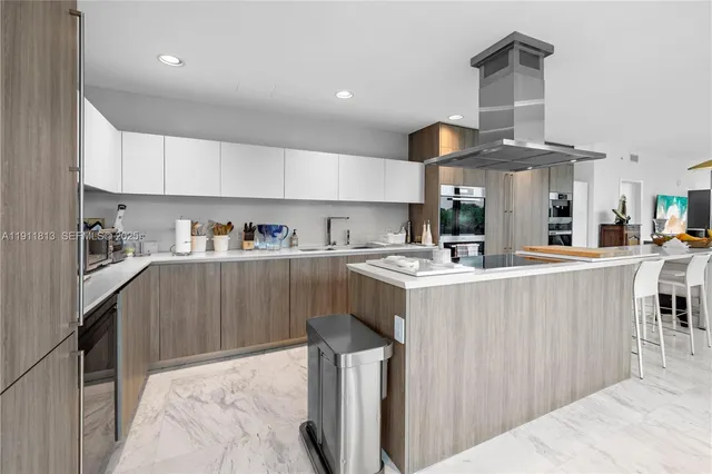 a kitchen with stainless steel appliances kitchen island granite countertop a sink and cabinets