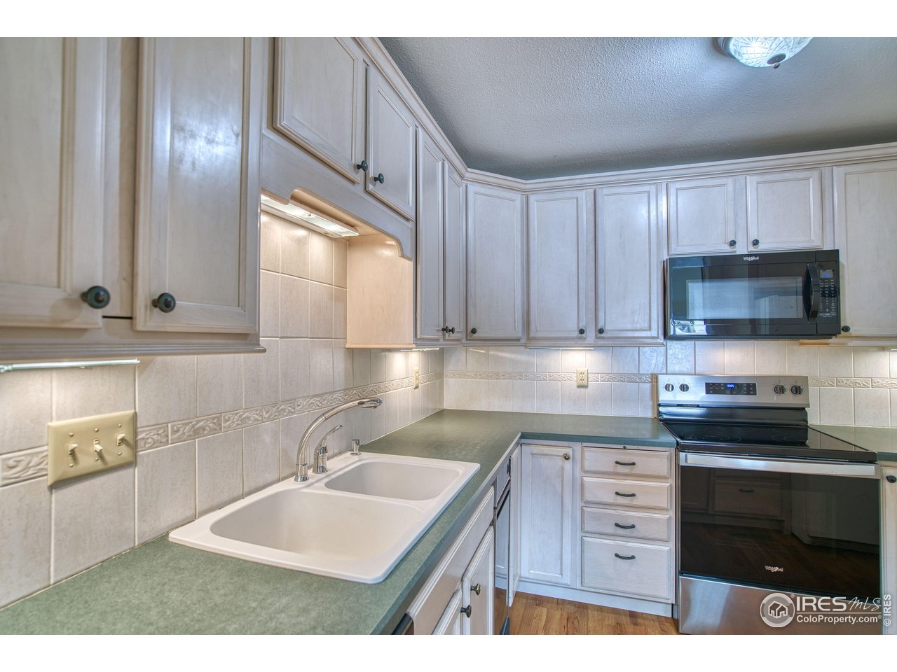 1925 28th Avenue, Unit 30 Greeley, CO 80634 - Photo 11 of 34 a kitchen with granite countertop a sink stainless steel appliances and cabinets