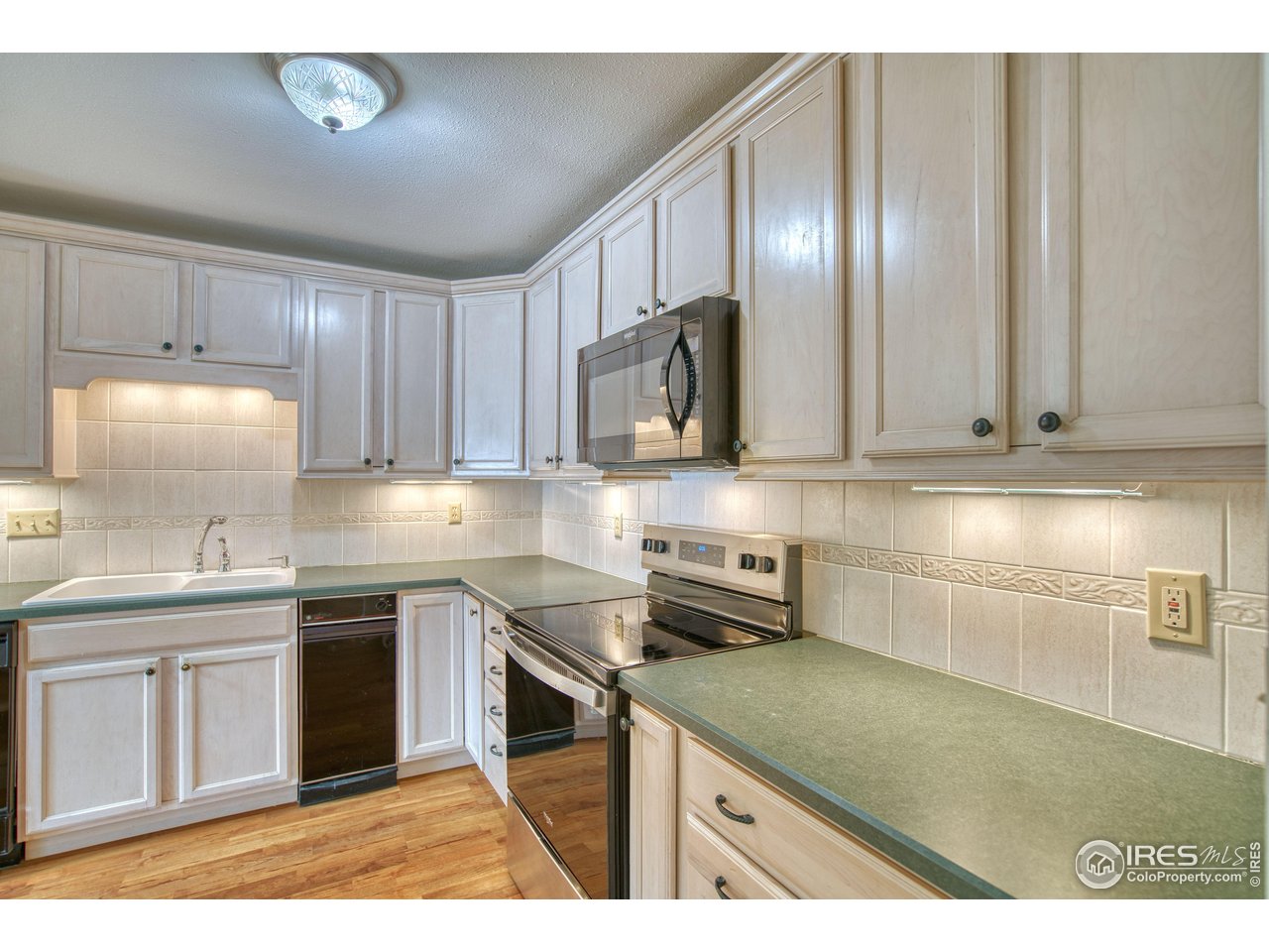 1925 28th Avenue, Unit 30 Greeley, CO 80634 - Photo 14 of 34 a kitchen with stainless steel appliances granite countertop a sink stove and microwave