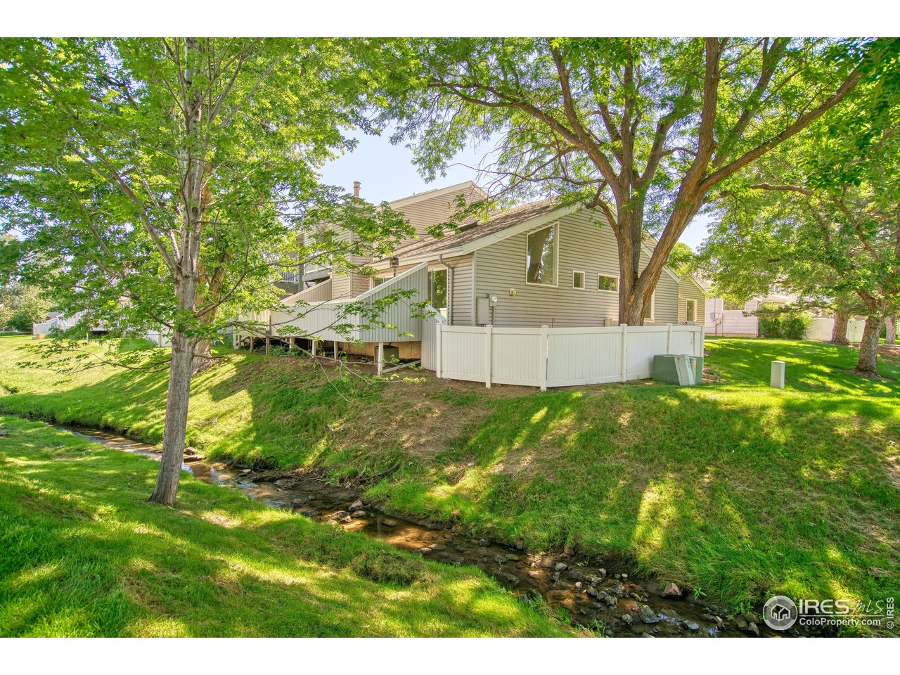 1925 28th Avenue, Unit 30 Greeley, CO 80634 - Photo 8 of 34 a view of a yard in front of a house with a large tree