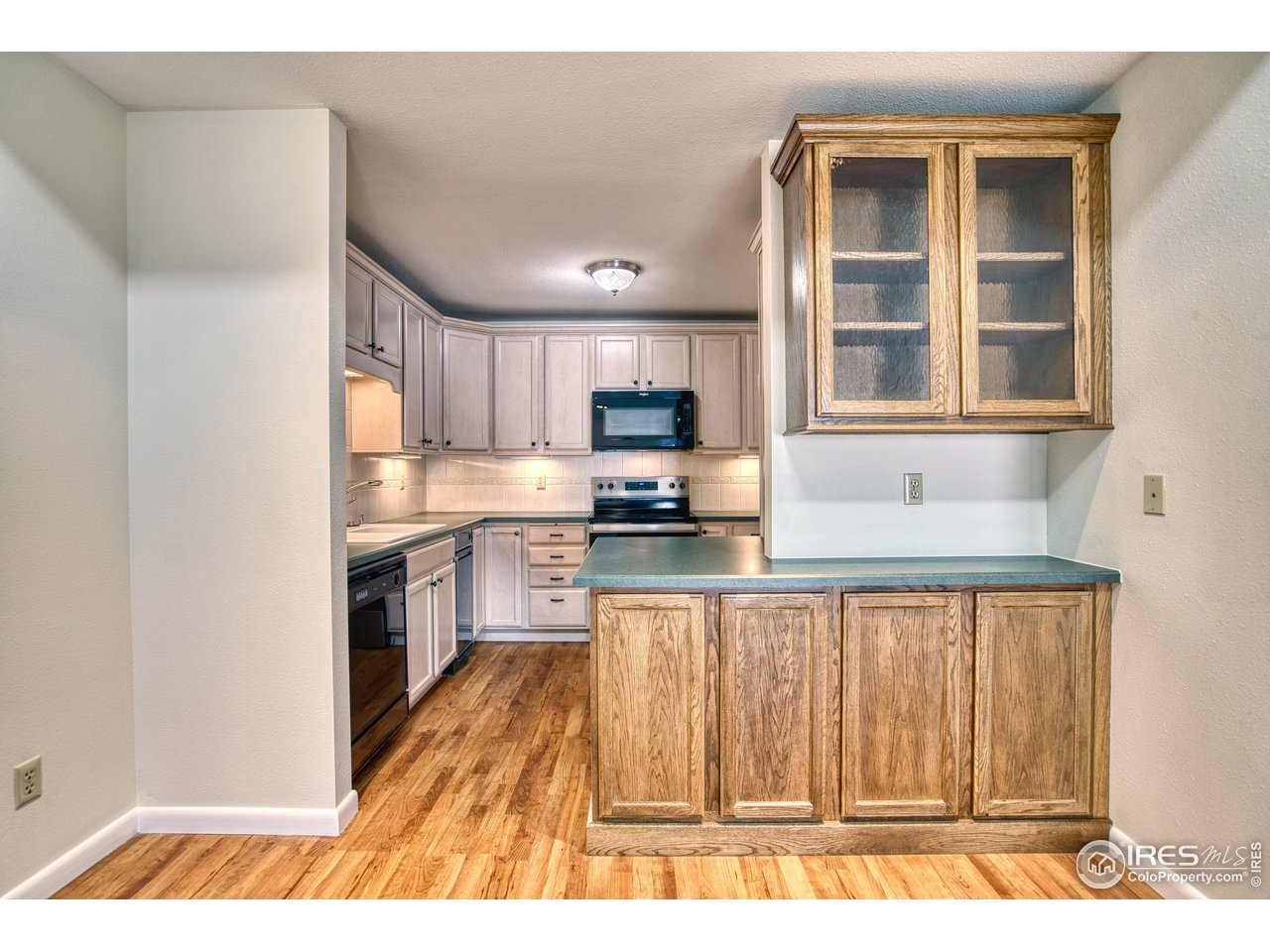 1925 28th Avenue, Unit 30 Greeley, CO 80634 - Photo 10 of 34 a kitchen with granite countertop a stove a sink and a refrigerator