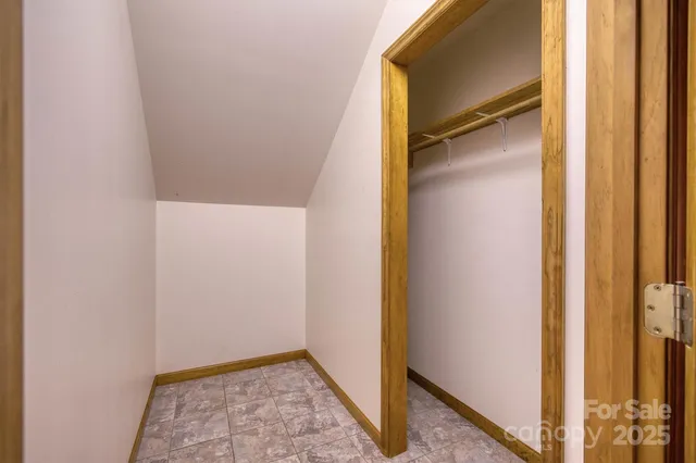 a view of hallway with closet and wooden floor