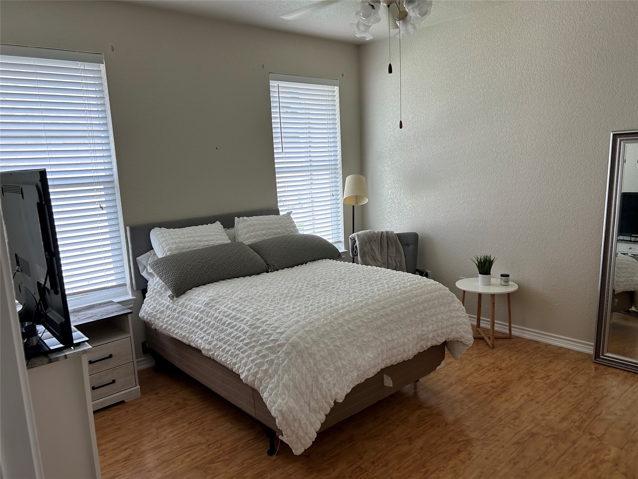 105 Sabine Drive Georgetown, TX 78628 - Photo 5 of 12 Bedroom with light wood finished floors, a textured wall, and a ceiling fan