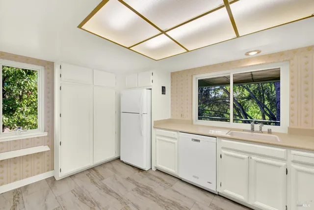a view of a kitchen with wooden floor and electronic appliances