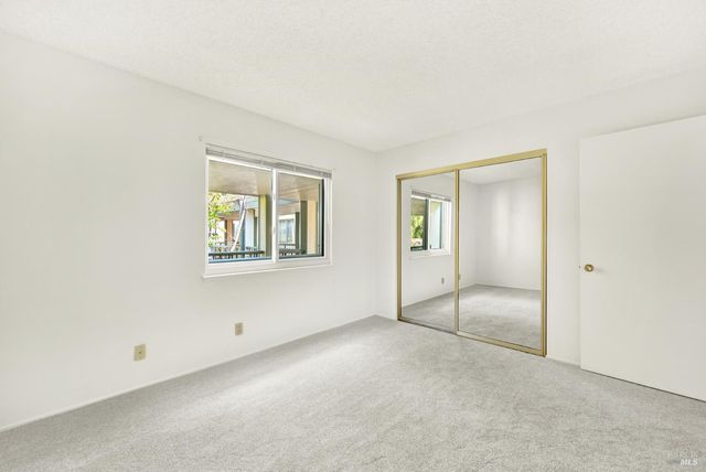 an empty room with windows and closet