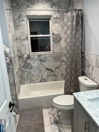 a bathroom with a granite countertop toilet a sink and bathtub