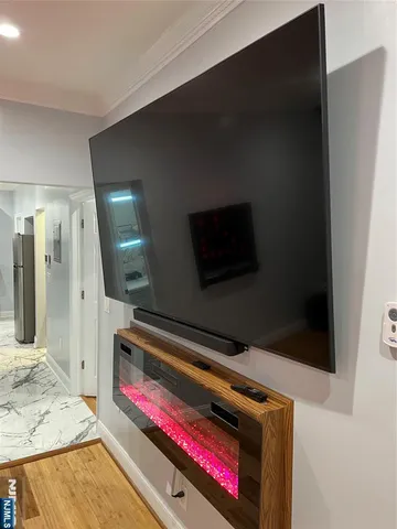 a living room with a flat screen tv and a wooden floor