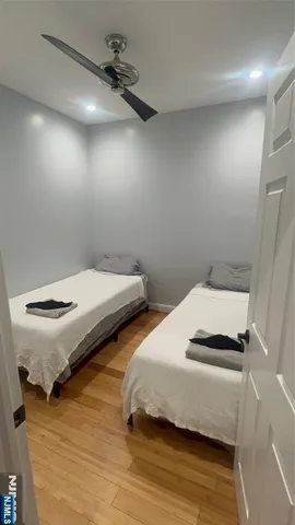 a bedroom with two beds and a ceiling fan