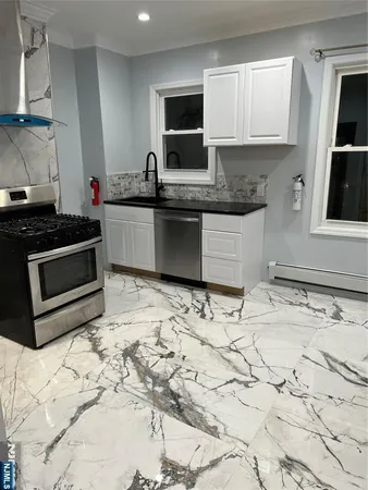 a kitchen with granite countertop a sink stove and cabinets