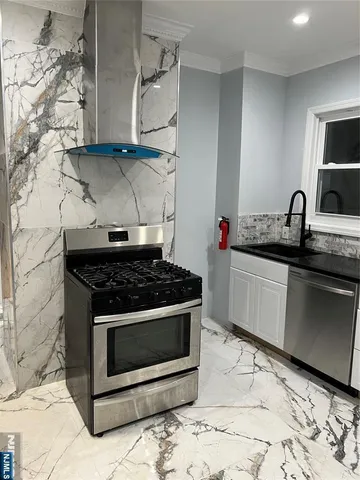 a kitchen with stainless steel appliances a stove a sink and a microwave