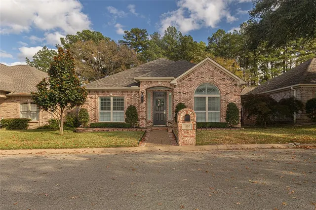 a front view of a house with a garden and trees