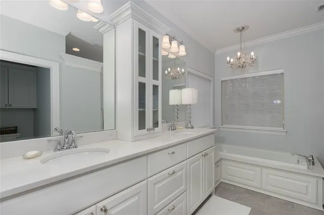 a bathroom with a sink double vanity granite tub shower and a mirror