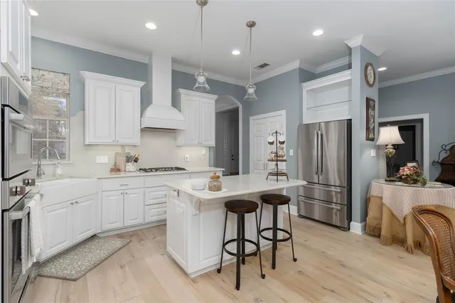 a kitchen with white cabinets and stainless steel appliances