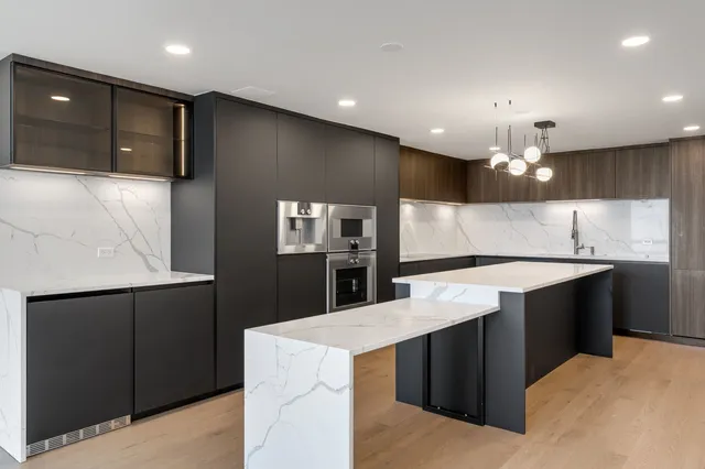 a kitchen with kitchen island sink and refrigerator