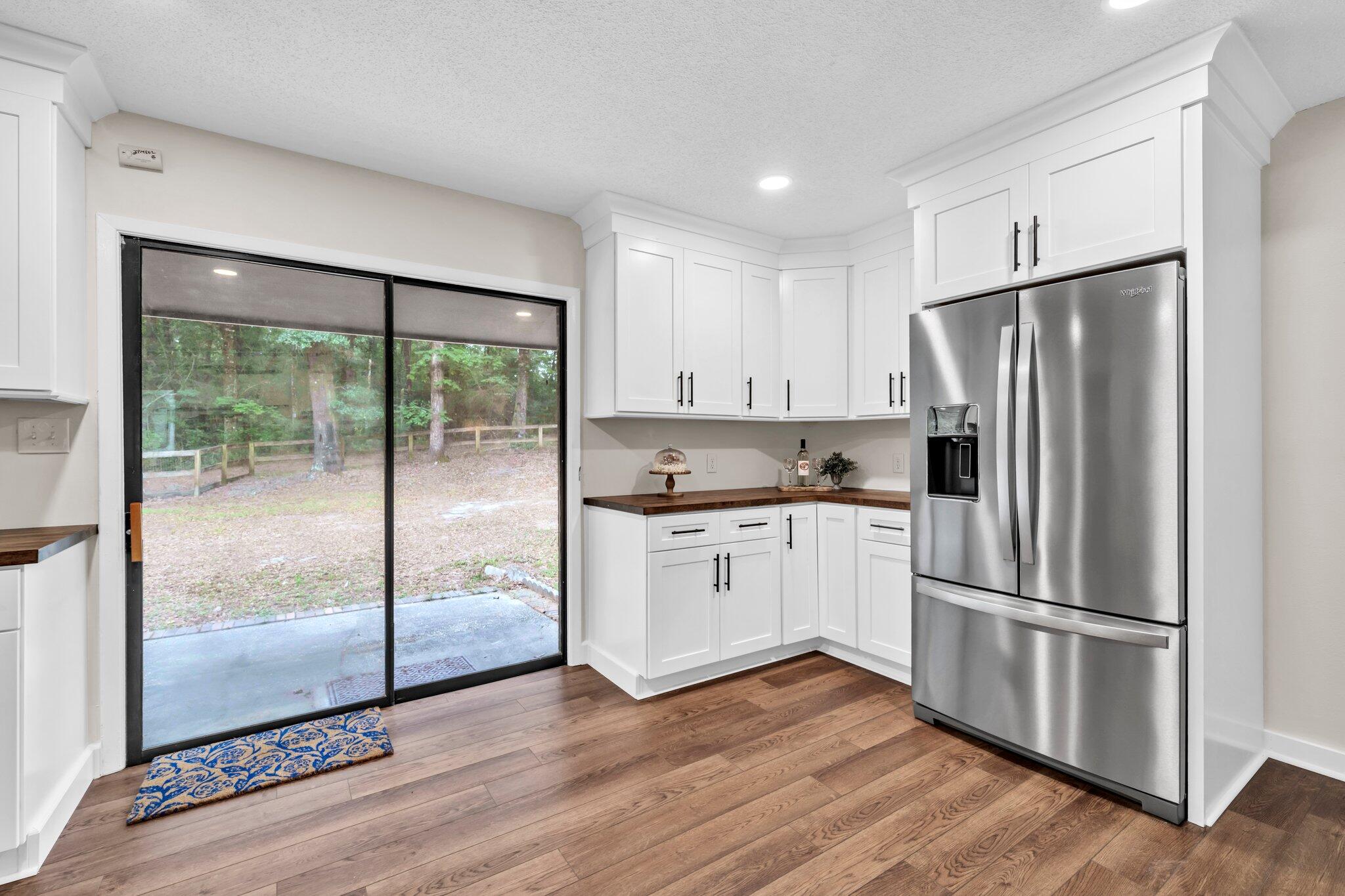 5241 Bob Sikes Road DeFuniak Springs, FL 32435 - Photo 14 of 35 a kitchen with stainless steel appliances granite countertop a refrigerator a sink and white cabinets with wooden floors