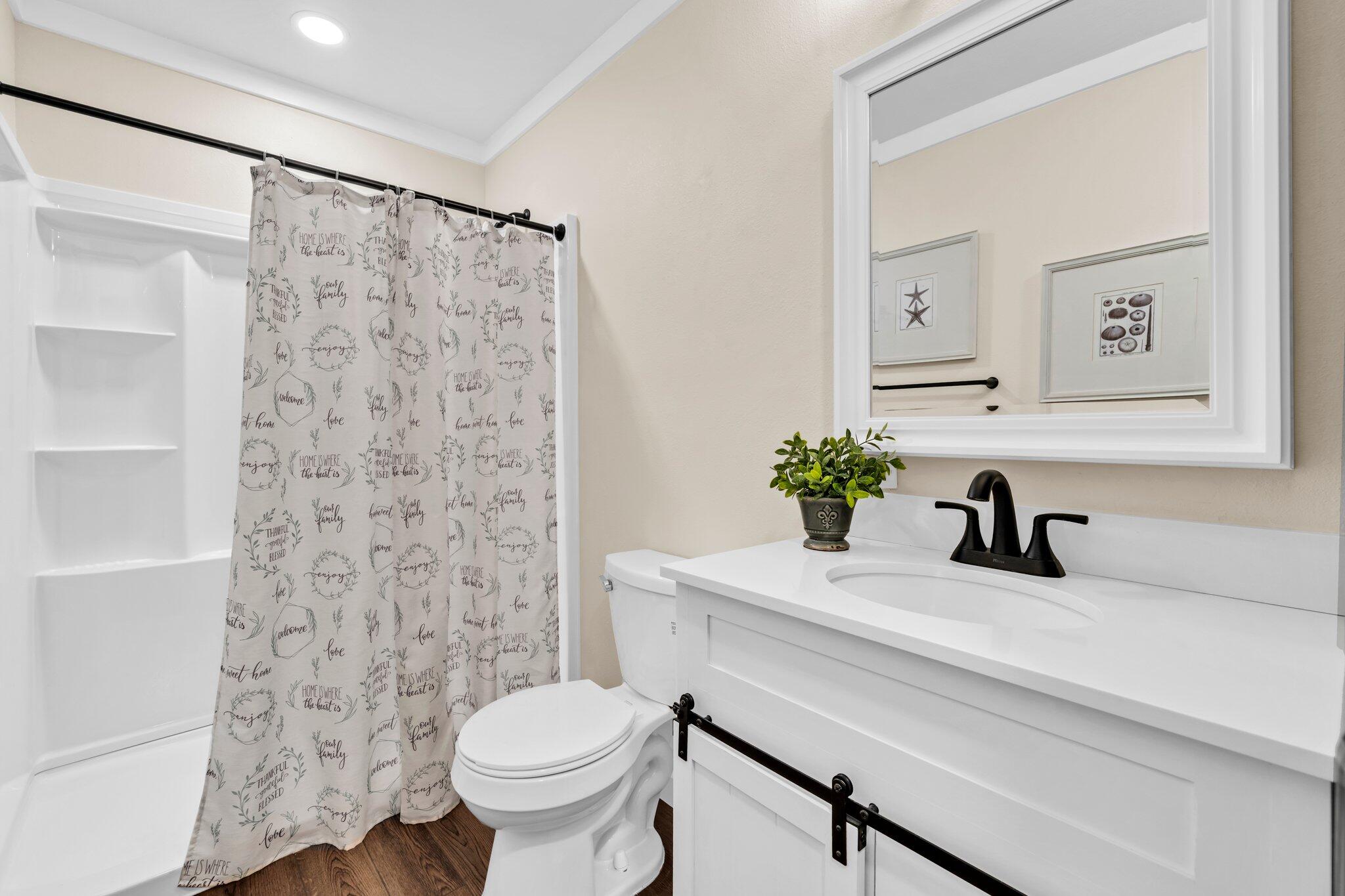 5241 Bob Sikes Road DeFuniak Springs, FL 32435 - Photo 26 of 35 a bathroom with a sink a toilet and shower curtain